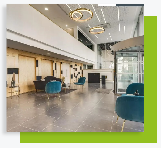 Hall d’accueil contemporain avec fauteuils bleus, sol carrelé et éclairages circulaires décoratifs