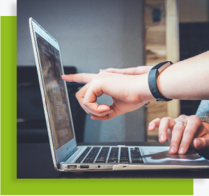 Personnes utilisant un ordinateur portable, l’une pointant l’écran pour expliquer une information