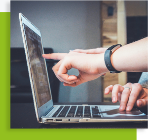 Personnes utilisant un ordinateur portable, l’une pointant l’écran pour commenter une information