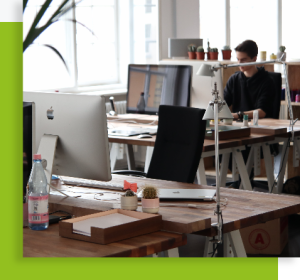 Bureau open space avec postes de travail, écrans et luminaires dans un environnement lumineux