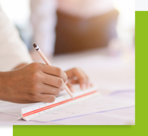 Main écrivant au crayon sur un document posé sur une table