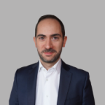 Personne portant un costume bleu et une chemise blanche sur fond gris